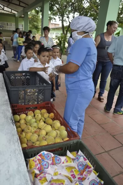 Niños de la escuela Oscar Mogollón reciben la merienda escolar.